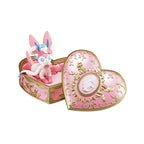 Pink heart-shaped box with a figurine inside on a white background